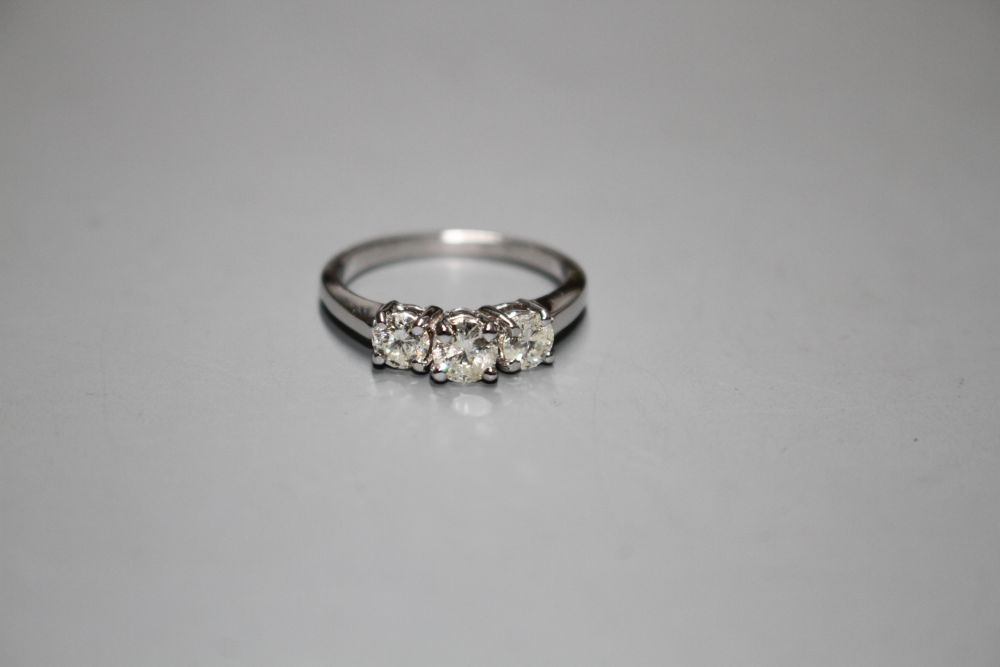 A modern 14k white metal and three stone diamond ring,
